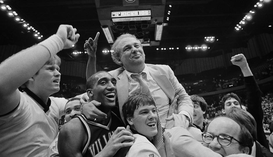 Basketball team celebrating with their coach.